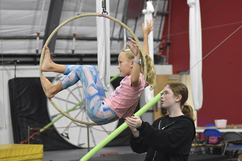 Dylan Welling, 8, practices in the lyra with couneslor Elle Singerman, 12.