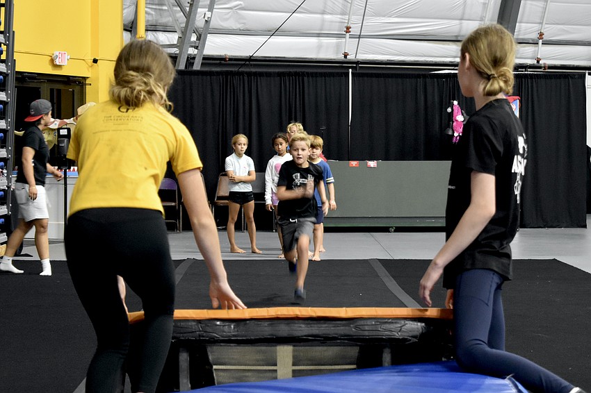 Counselor Ella Abrahamson, 13, Ryan Miller 6, and Madison Barrett, work with the mini trampoline.