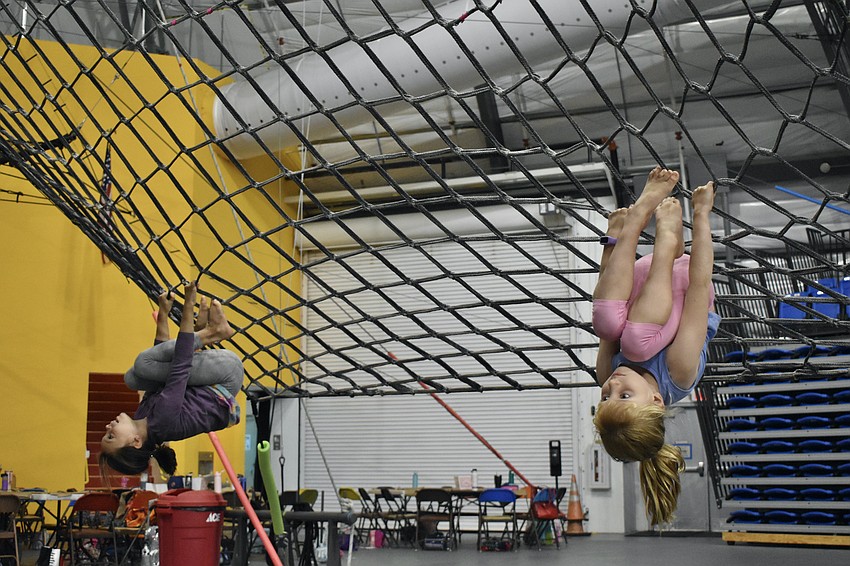 Anna Polk, and Violet Hoefer, 7, hang from the cargo net.