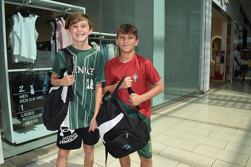 Venice's Nate Martin and Christian Dunn, who are both 10, receive free backpacks during the Back to School Bash at the Mall at UTC.