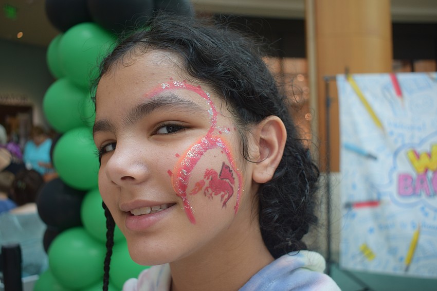 Sarasota's Jazmine Akal, who is 9, has a dragon painted on her face. 