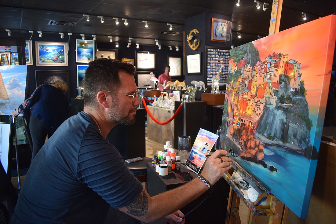Michael DeWulf painting at his live art show at Wyland Gallery on Aug. 4.