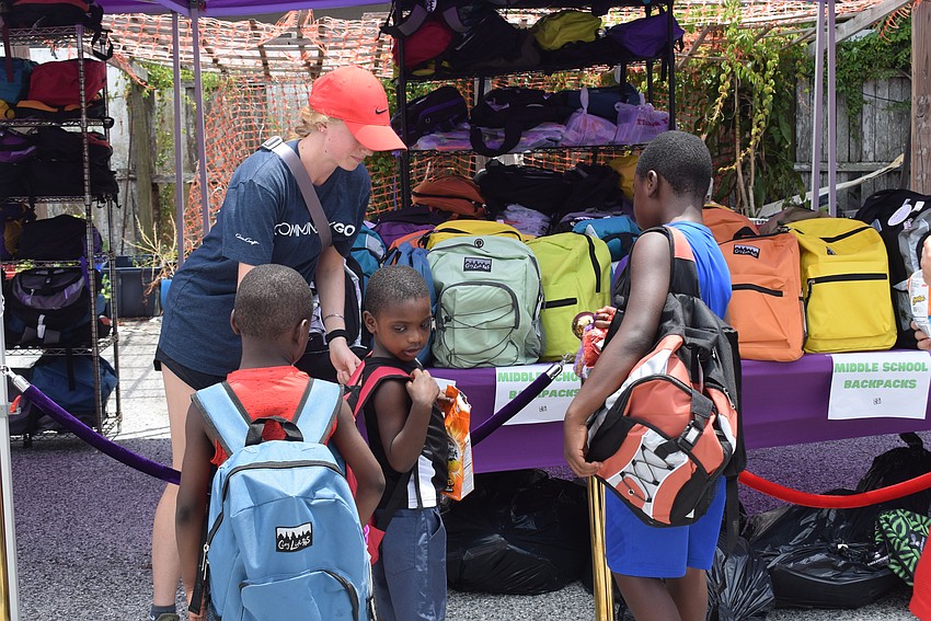 Children at the SCLO back-to-school drive try on new backpacks.
