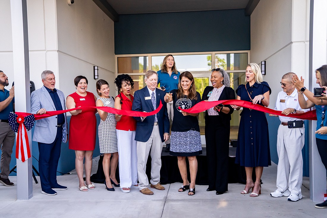 Dreamers Academy founder Geri Chaffee (center) cuts the ribbon at the Newtown campus.
