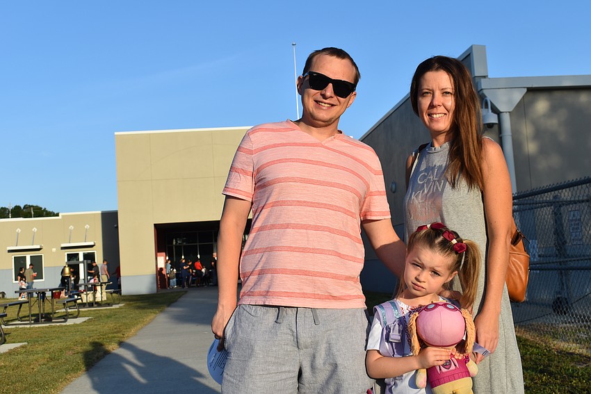 Val and Hanna Wide drop off their 5-year-old Emily, who carries a friend for her first day in kindergarten at Freedom Elementary.