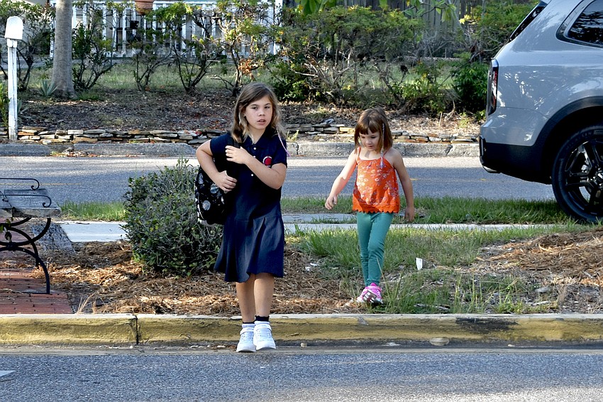 Osselyn Hart, 9, followed by her sister Etta Hart, 4, walk towards the building.