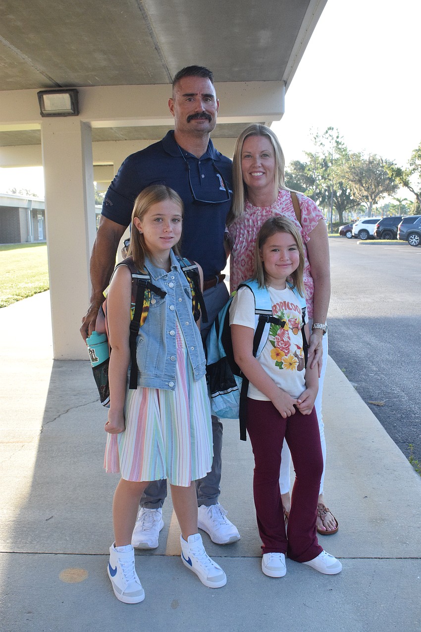 Phil Heuss and Vanessa Heuss prepare to drop off their daughters, fourth grader Clara Heuss and second grader Jolene Heuss, in their classrooms at Gene Witt Elementary School.