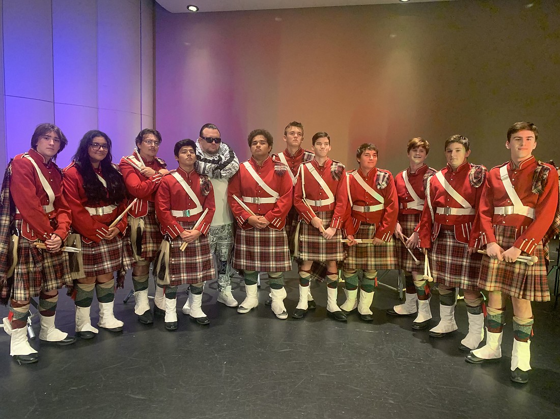 Rapper Ryanito poses with the Riverview Kilties, who were featured in his recording of the theme song for the Sarasota Paradise soccer team.