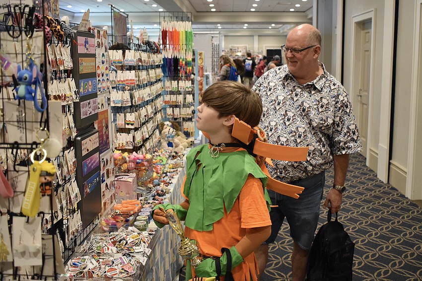 Chance Horvath, 13, holding the trophy he received for Best Youth Costume after dressing as Skull Kid from The Legend of Zelda video game series, browses the stands with Scott Blomeley.