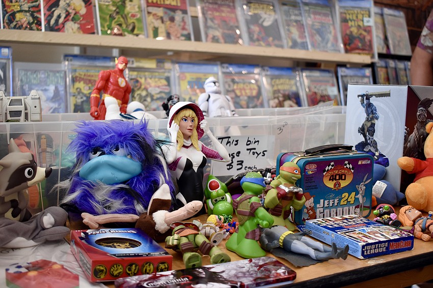 Memorabilia from various media franchises is set out on display.