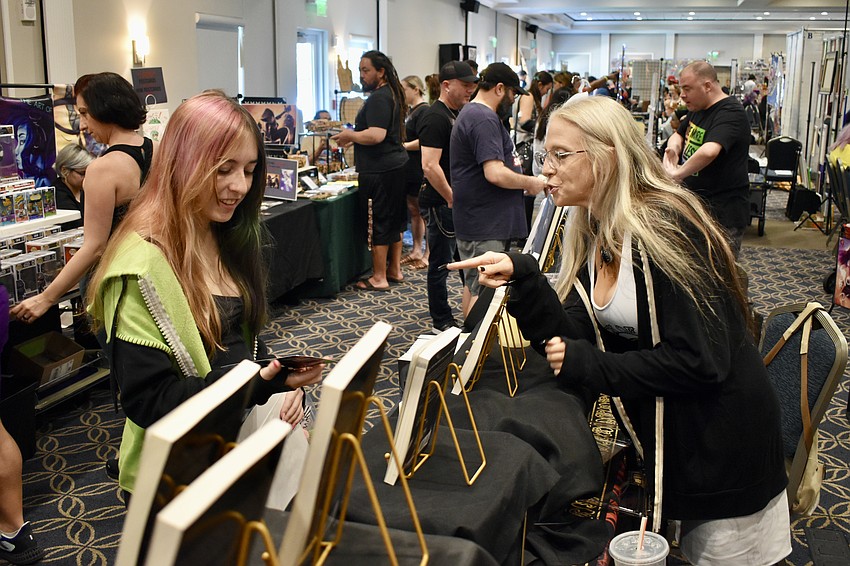 Megan Farrell browses works by Maria DeVivo, a Tampa area horror and dark fantasy author.