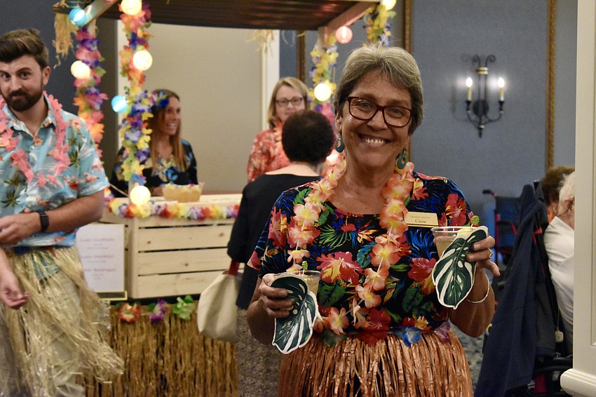Facet Assistant Crow Barnett serves mai tais to residents.