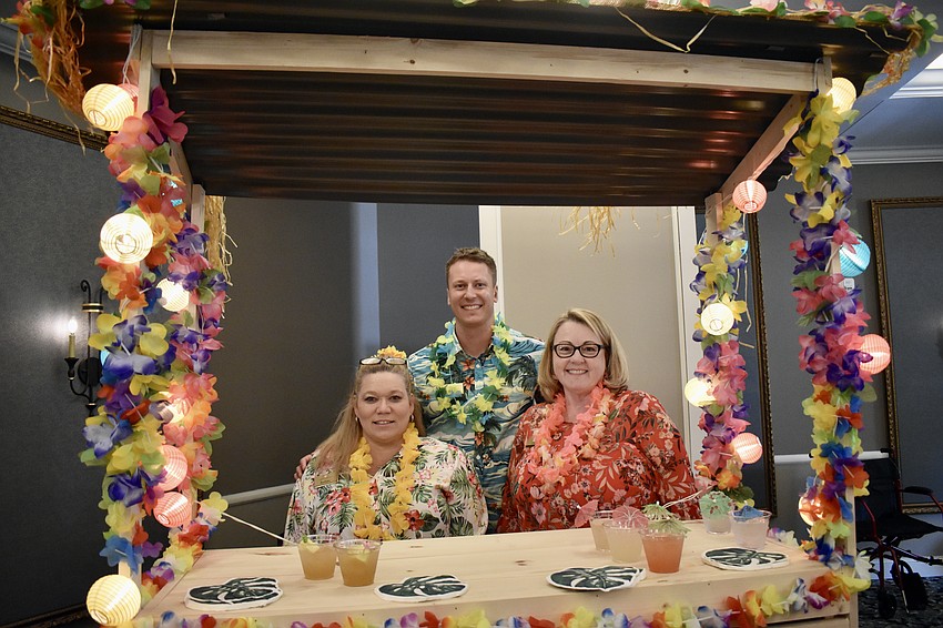 Barbara Allen, Tyler Smith and Debbie Bonnes trade their normal work attire for Hawaiian shirts.
