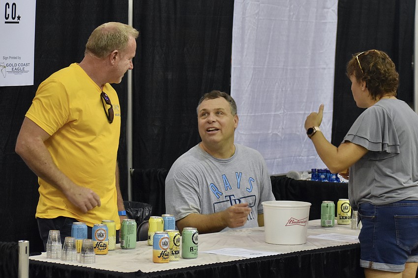 Joseph Keogh and Mark Metallo, of the Big Top Brewing stand, serve Karissa Mayer