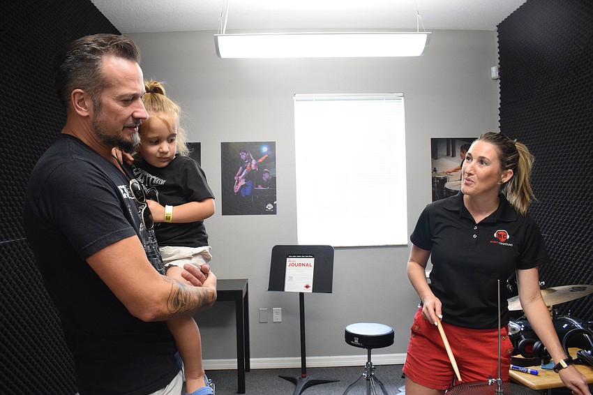 Palmetto's Edward Whay and his 2-year-old Ocean Whay learns about the various lessons available from Music Compound owner Jenny Townsend.