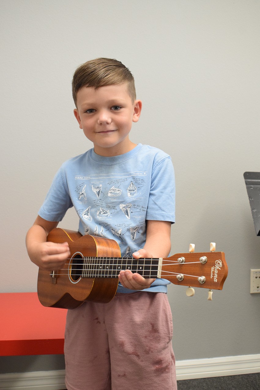 Bradenton's Alexandre Kirkland, who is 7, tries a ukulele. During his tour of Music Compound's Bradenton location, he counted every guitar he saw in the building.