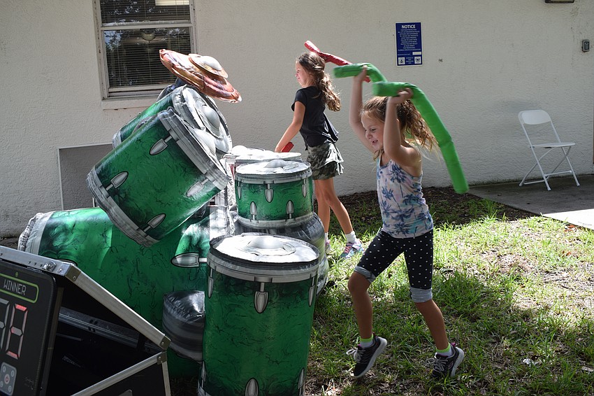 East County's Ellie Hatch, who is 8, competes against her 6-year-old sister, Lauren Hatch, in a game to see who could hit the drums the most times. Lauren Hatch won the first round.