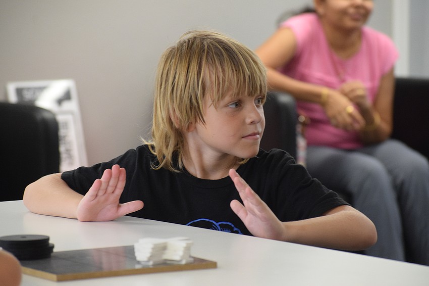 Palmetto 6-year-old Jason Kirk uses the table to drum along to Nirvana's 