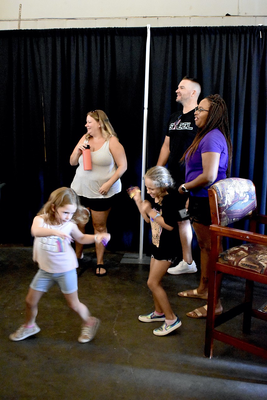 6-year-old Eliza Burdo, Sophie O'Leary, 6-year-old Sadie O'Leary, Michael Burdo, and Kensey Burdo enjoy a student performance.