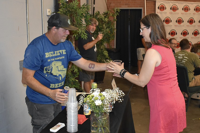 Dean Lambert of Big Top Brewing offers a drink to Lucia Drage.