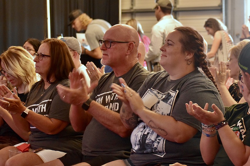 Kristen Emmons, Rick Emmons, and Brittany Emmons applaud the student performers.