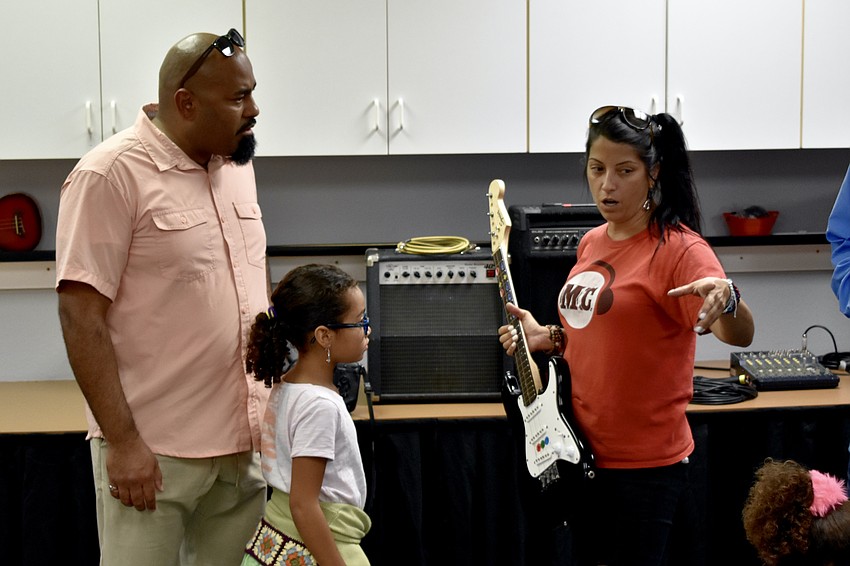 Ivan Sanchez and 6-year-old Alondra Sanchez learn about Music Compound