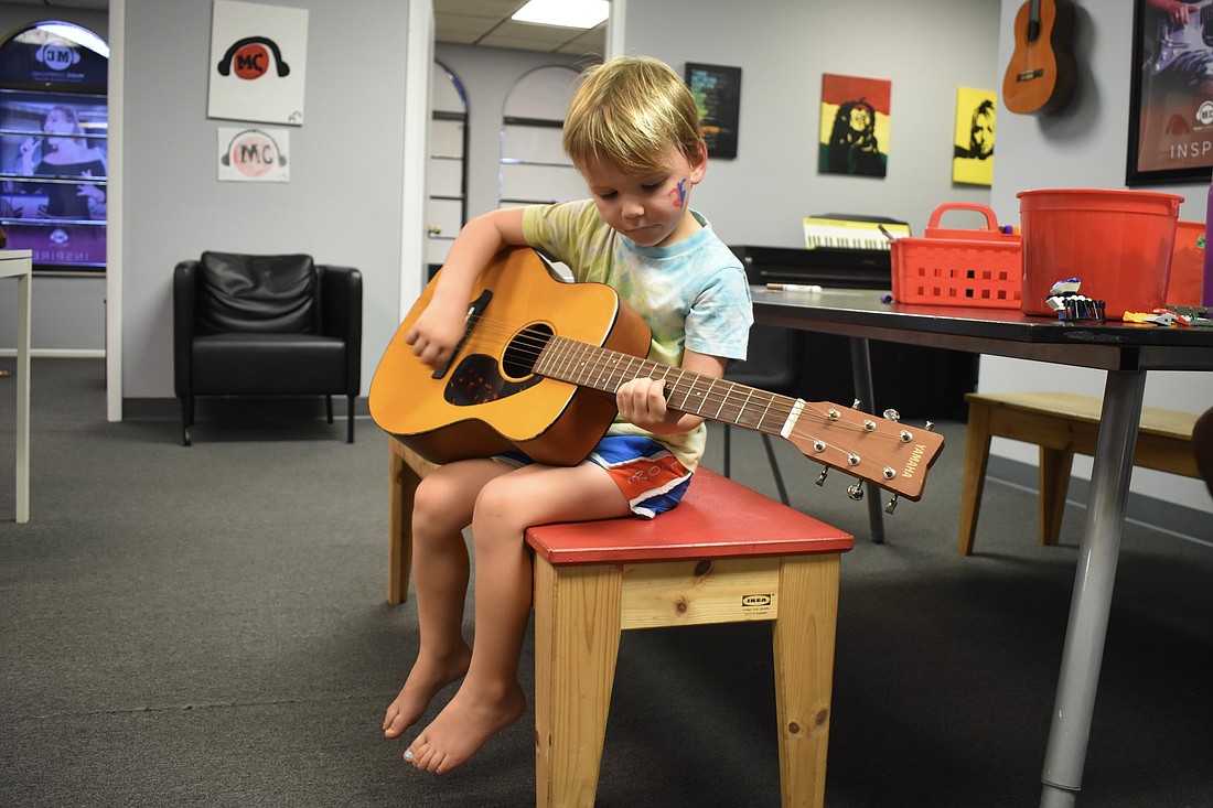 3-year-old Cameron Benfer relaxes with a guitar.