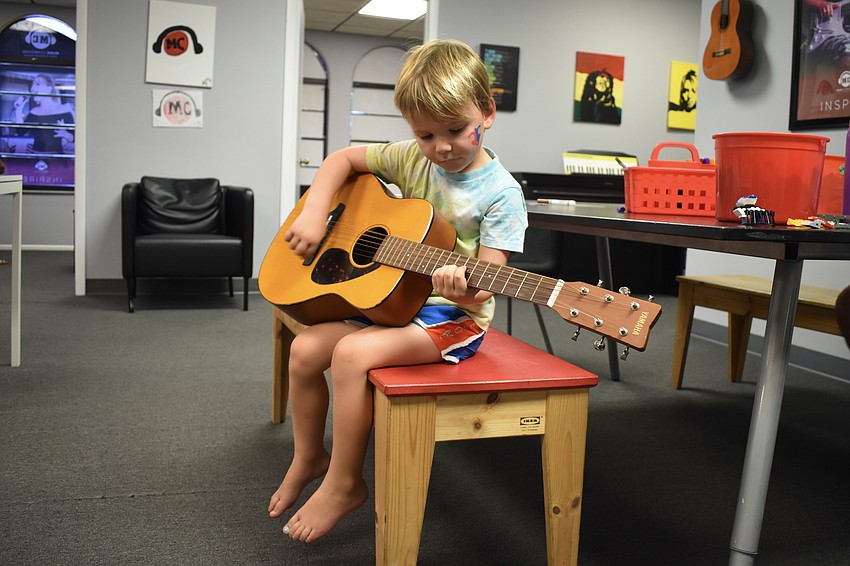 3-year-old Cameron Benfer relaxes with a guitar.