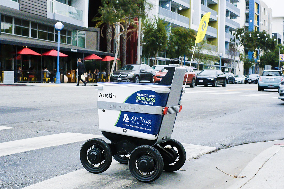A robotic delivery vehicle with ads branded by Tampa-based Nickelytics.