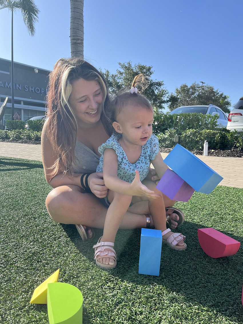 Sarasota's Juliana Beister helps her 2-year-old daughter Mila Beister build a tower.