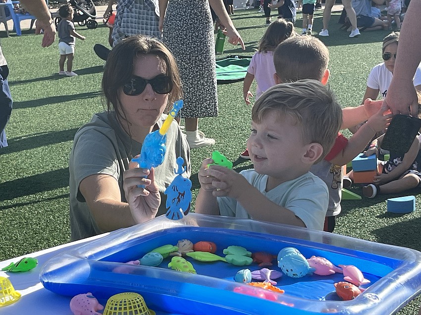 Sarasota's Audrey Able and her 2-year-old son Phineas Able try fishing. Audrey Able says her son was hesitant to play at first because it wasn't long before he was having fun.
