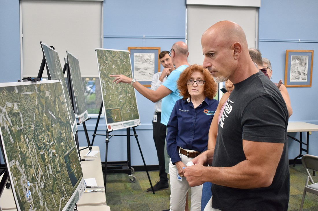 Deputy Director of Development Services Denise Greer stands by for questions, as Robert Giarraputo looks at a map of his neighborhood. Giarraputo attended the workshop to offer input on Manatee County's comprehensive plan.