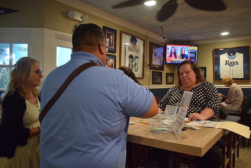 Chamber members check in for Networking at Noon at the Lazy Lobster on Aug. 24.
