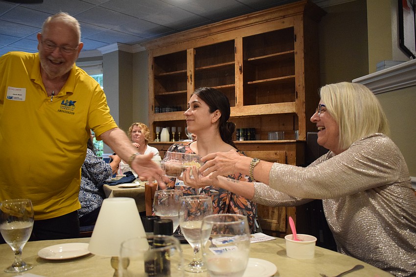 Jack Dean giving Liz Yerkers cupcakes she won in a raffle at the Chamber's Networking at Noon.