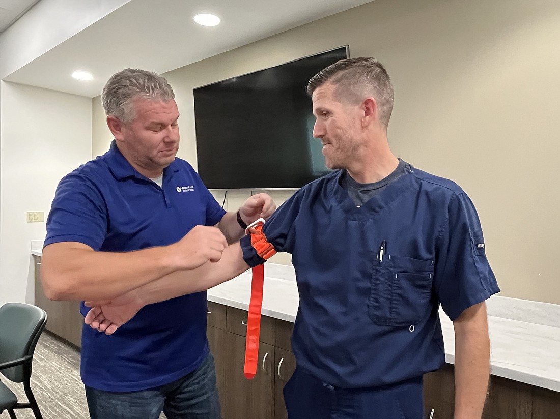 Jamie Billingsley, the emergency manager at Lakewood Ranch Medical Center, demonstrates how to use a tourniquet with Stephen Arnold, the patient experience manager.