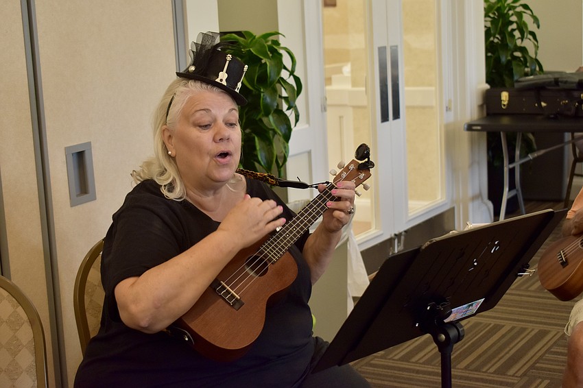 Aloha Ukulele President Alice Baumann leads the group in a rendition of 
