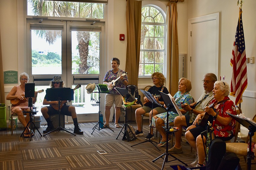 A big circle forms in Town Hall for Play Music on the Porch Day. Residents brought their ukuleles and guitars.