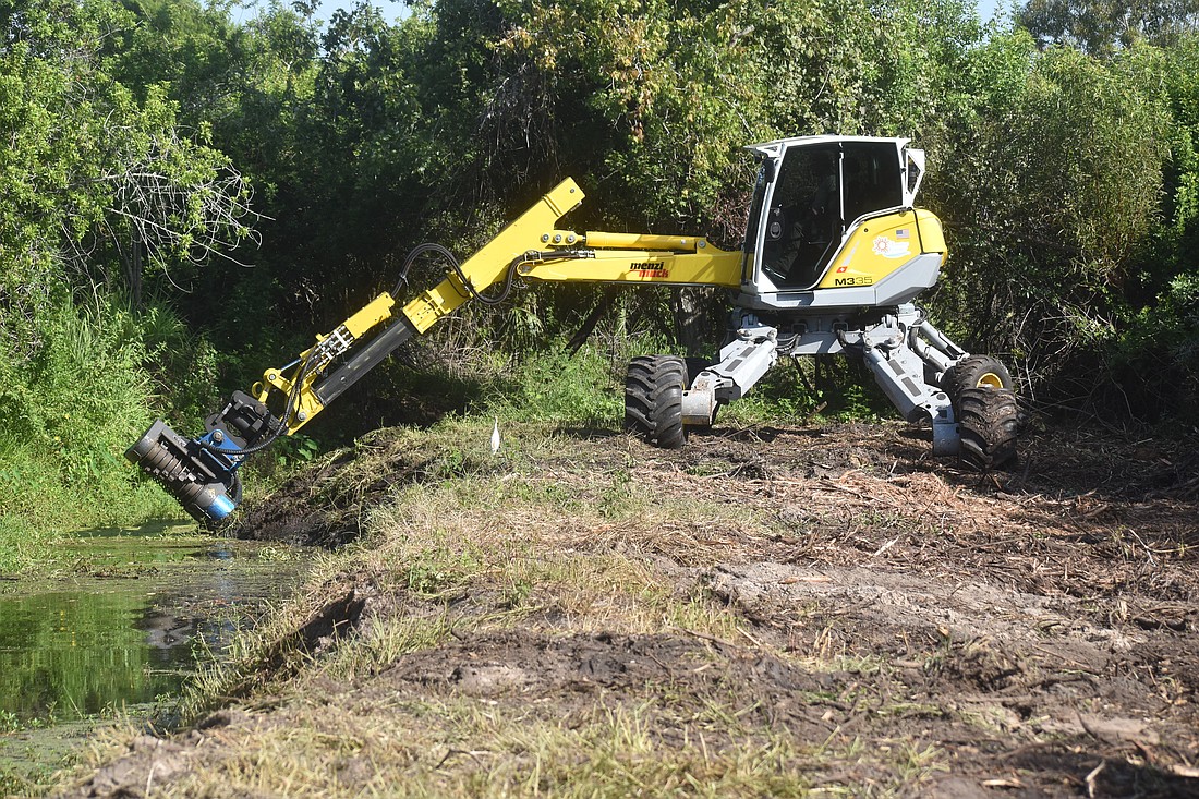 A Menzi Muck machine owned by Manatee County makes clearing out a canal an easier proposition.
