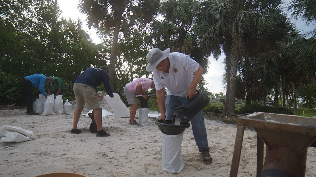 Longboat Key Town Manager Howard Tipton lended a helping hand at sandbag distribution early Tuesday morning.