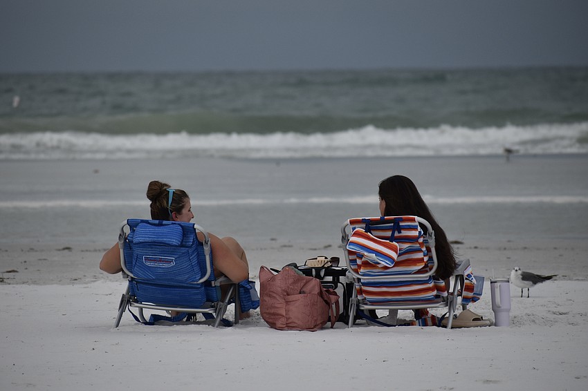Rylie Hollar and Kayley Robinson watch the rough seas on Tuesday at Siesta Key Beach.