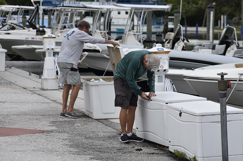 Mark Rainey and John Robinson of Freedom Boat Club take inventory in advance of the storm at Bayfront Park on Tuesday.