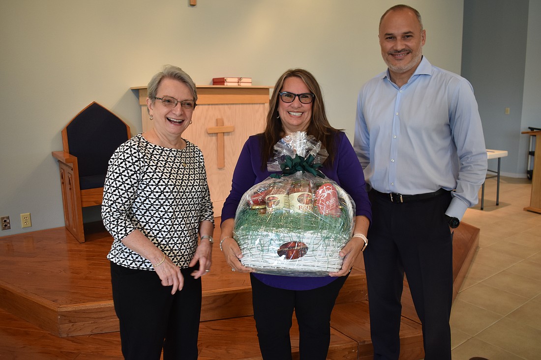 Our Lady of the Angels' Pat Martino joins Catholic Charities' Gloria Romero and Eddie Gloria as they collect items for the Boots and Bandanas' silent auction.