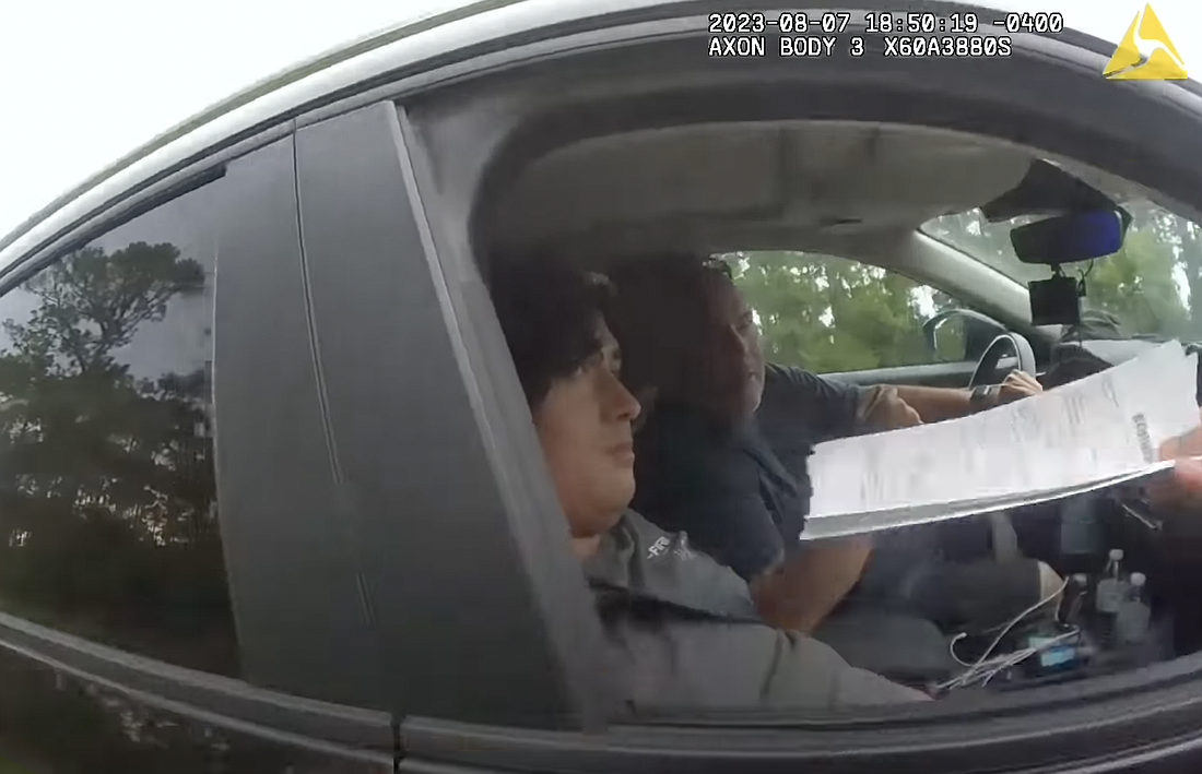 FCSO Master Deputy Kyle Gaddie hands Jeff Gray, a civil rights investigator on social media, two traffic citations. Image screen shot from HonorYourOath YouTube video, "Bird Watching with Deputy Gaddie"