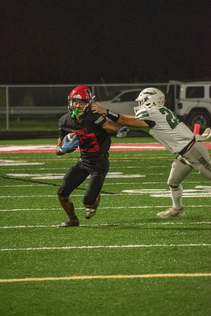 Cardinal Mooney sophomore Bo O'Daniel (23) is dragged down by Lakewood Ranch sophomore Mike Turner on a punt return.