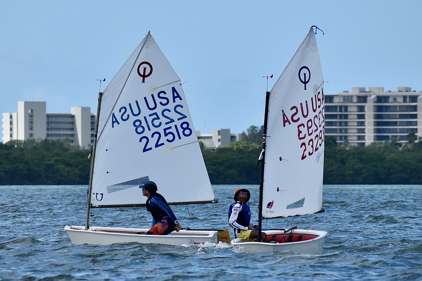 Griffin Roberts (Optimist RWB — Red) of Sarasota Yacht Club and Rafi Ahmed (Optimist RWB — Blue) of Sopraventus/Chicago Yacht Club compete with one another.