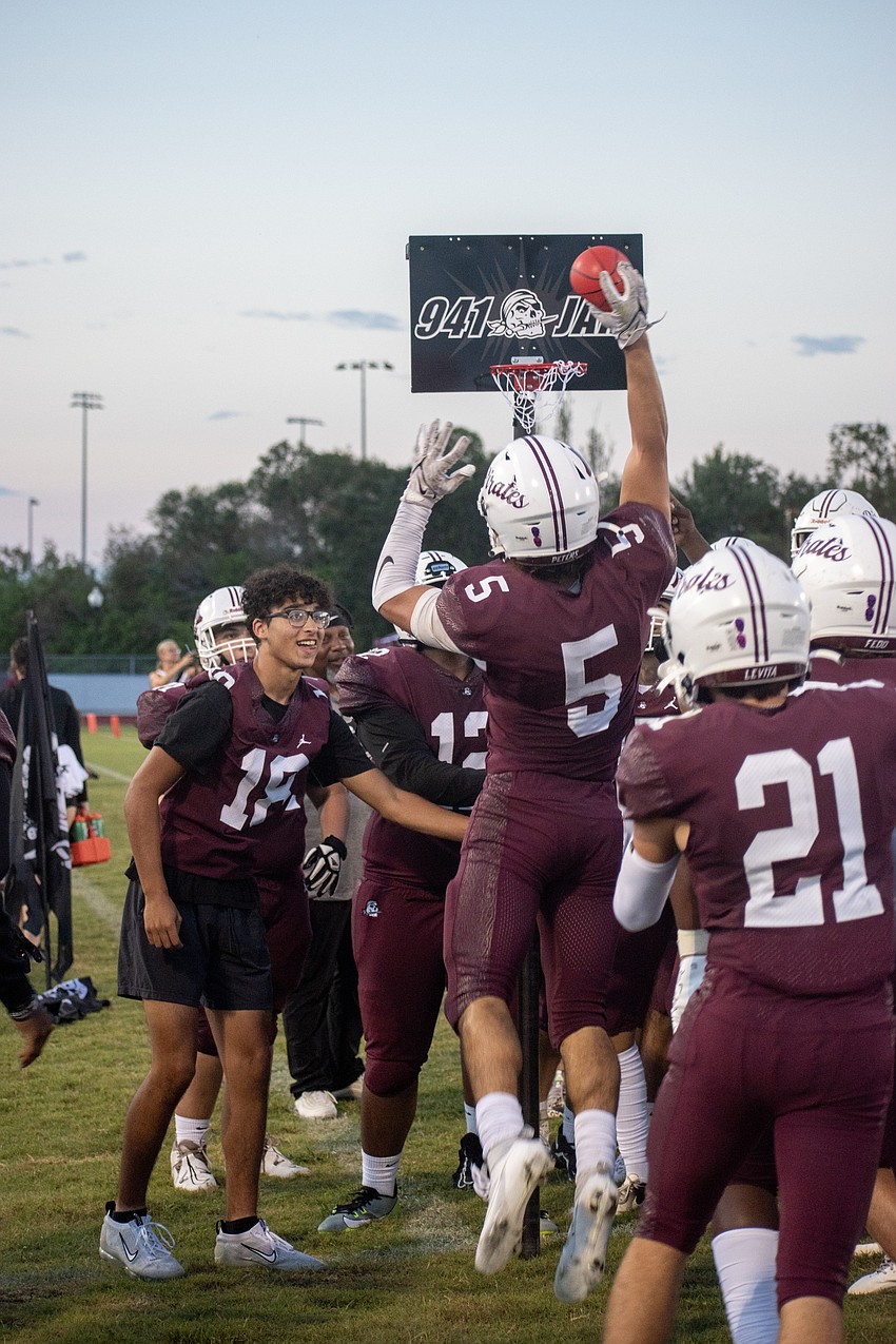 Braden River senior Ryan Peters dunks on a miniature hoop on the Pirates' sideline after securing an interception against Lakewood Ranch.