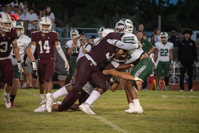Braden River senior linebacker Micah Fedd (33) and sophomore defensive lineman Myles Holmen (99) combine to take down Lakewood Ranch senior running back Teagan Randall.