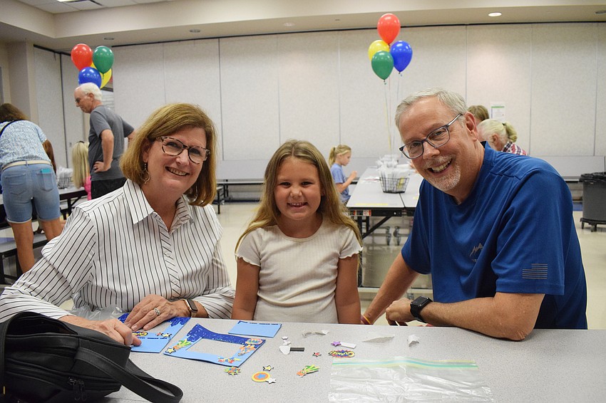 Jan Medford makes picture frames with her granddaughter MaryKate Medford, a first grader, and her husband, Morgan Medford. 