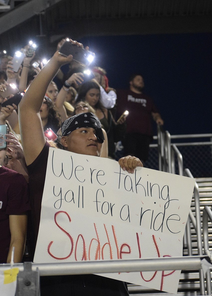 Braden River High School senior Isidoro Escamilla Sanchez holds up a poster meant for the Lakewood Ranch High School Mustangs.