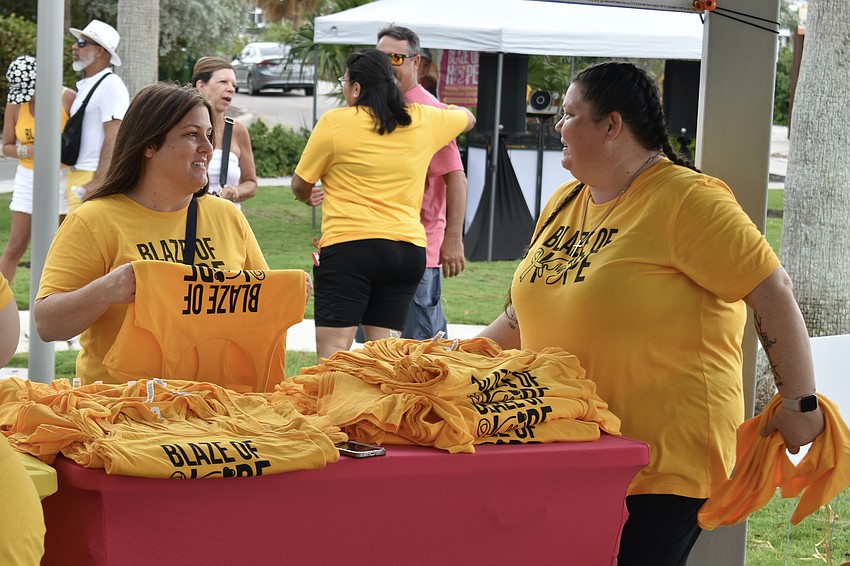 Lisa Moore, CEO and founder of Blze of Hope, talks with Vice President April Barnes during the distribution of shirts before the event.